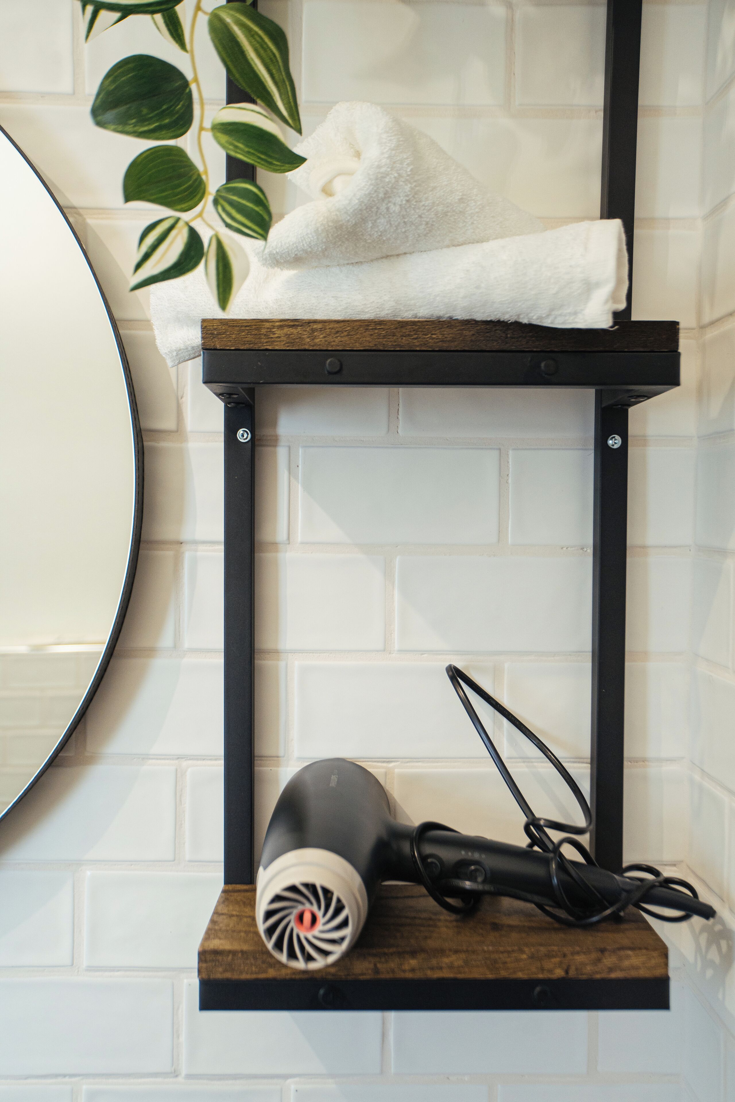 A bathroom with a towel rack, a hairdryer, and a mirror.
