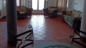 Ein geräumiges Wohnzimmer mit zwei Sofas, einem Couchtisch und einem Deckenventilator.