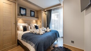 Un dormitorio moderno con una cama grande, cabecera de madera y un tapete de piel.