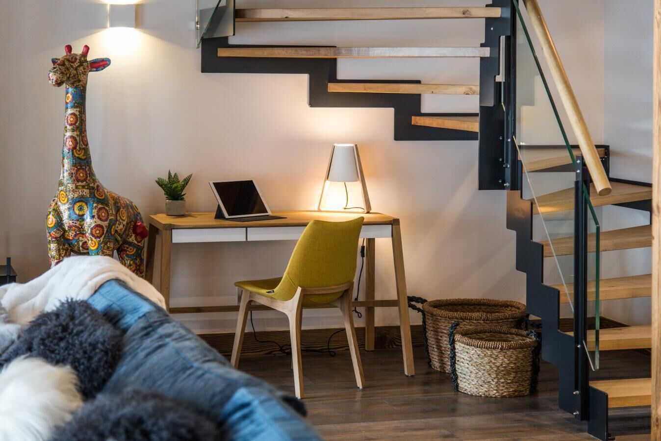 A modern room with a desk, chair, and a spiral staircase.