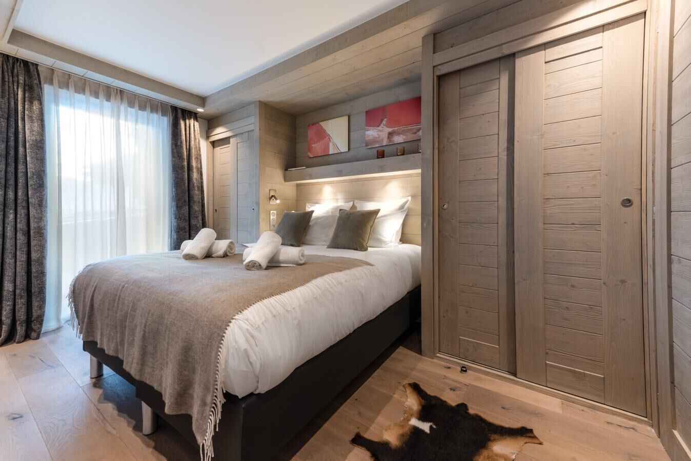A bedroom with a large bed, wooden headboard, and a wardrobe.