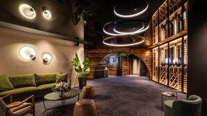 Un espace de détente moderne avec un canapé vert, une table basse ronde et des éléments décoratifs en bois.