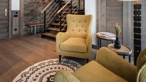 Um interior moderno com escada, uma poltrona amarela e um tapete redondo.
