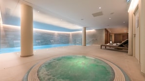 A spa area with a hot tub, a lounge chair, and a wall with a water feature. - Wifi, 200m from ski slopes, 4th floor, balcony, fireplace or stove, parking, tv, 82m², Les Gets (Les Gets)