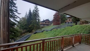 A balcony with a view of a hillside with stairs leading up to a building. - 180m from ski lifts, floor -2, balcony, tv, ski locker, 32m², Valfréjus (Valfréjus)