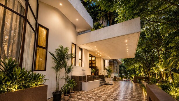 Un bâtiment moderne avec un sol à carreaux, des plantes en pot et un escalier menant à un niveau supérieur.