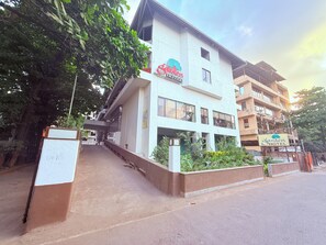 A hotel with a sign reading 'Garden Hotel,' a staircase leading to the entrance, and a large tree to the left. - Hotel Garden  (Panvel)
