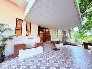 A modern building with a tiled entrance, a staircase, and a large window. - Hotel Garden  (Panvel)