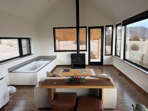 Una cocina moderna con un ventanal grande, una estufa integrada y una mesa de comedor de madera.