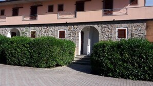 A two-story building with stone arches and a paved entrance.