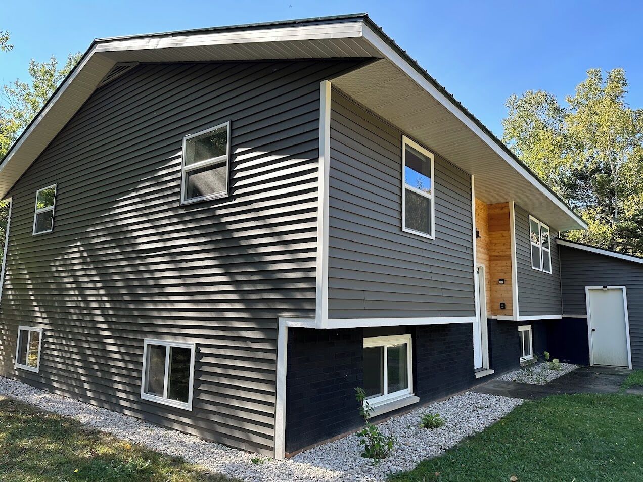 A two-story house with a sloped roof, a front porch, and a garage.