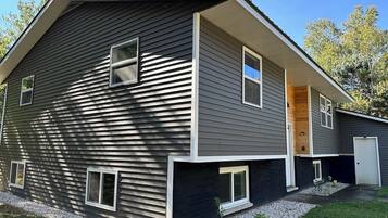 A two-story house with a sloped roof, a front porch, and a garage.