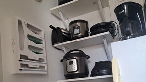 A compact kitchen with a toaster oven, a blender, a rice cooker, and a coffee maker on shelves. - 🌴Luxe Oasis🌴 (Miami)
