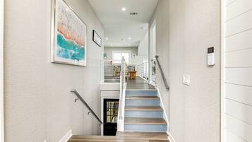 A staircase with wooden steps and a metal railing, leading to an upper floor.