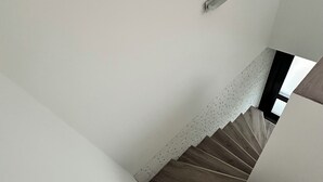 A staircase with wooden steps and white walls. - Vacation apartment / trade fair apartment - quietly located on the outskirts of Krefeld  (Krefeld)