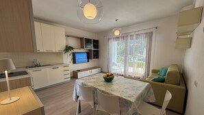 A modern living space with a kitchen, dining area, and a sofa.