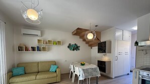 A modern kitchen with a dining area, wooden ceiling, and built-in cabinets.