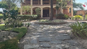 Un edificio con fachada de piedra, varios arcos y techo rojo.