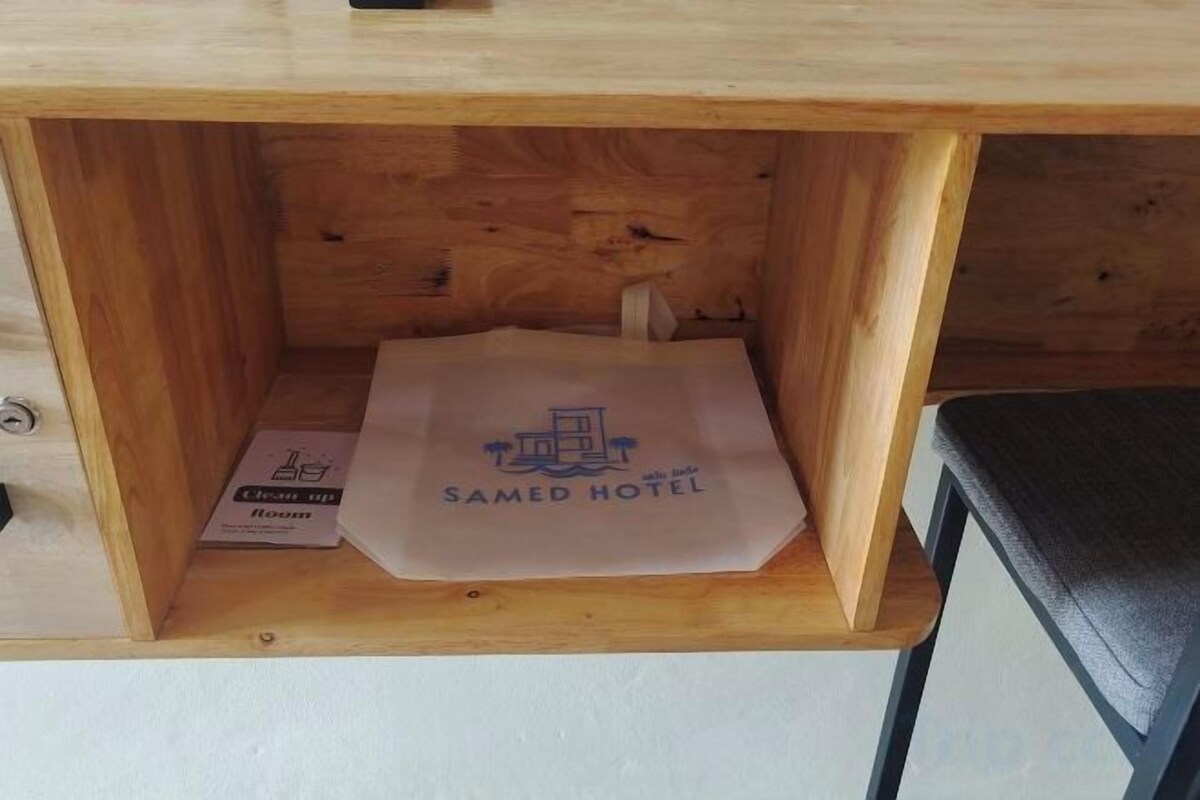 Una scatola di legno contenente una borsa bianca con l'etichetta 'SAMED HOTEL'.