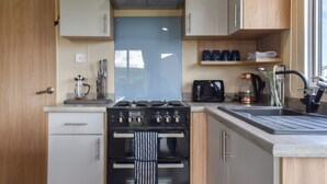 A modern kitchen with a stove, sink, and various appliances. - 2 bedroom accommodation in Moota, near Cockermouth (Moota, near Cockermouth)