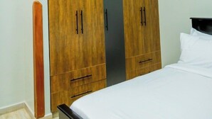 Ein Schlafzimmer mit einem Bett, einem Holzschrank mit zwei Türen und einem Nachttisch.