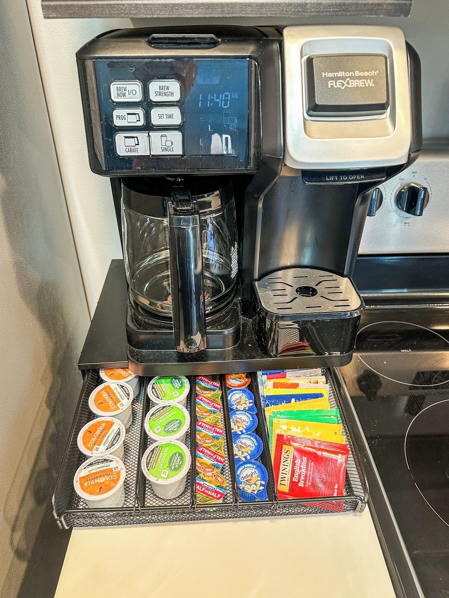 A coffee machine with a digital display and a Hamilton Beach Flexbrew coffee pod holder.