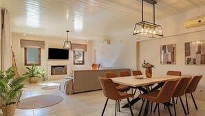 Ein modernes Wohnzimmer mit Essbereich, Kamin und Flachbildfernseher.