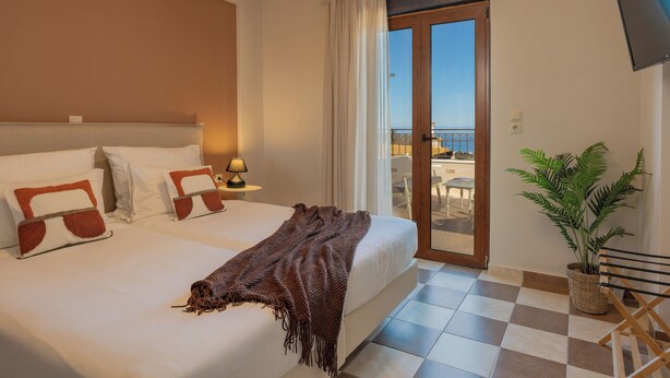 Ein Hotelzimmer mit einem großen Bett, einem Balkon mit Blick und einem Blumentopf.