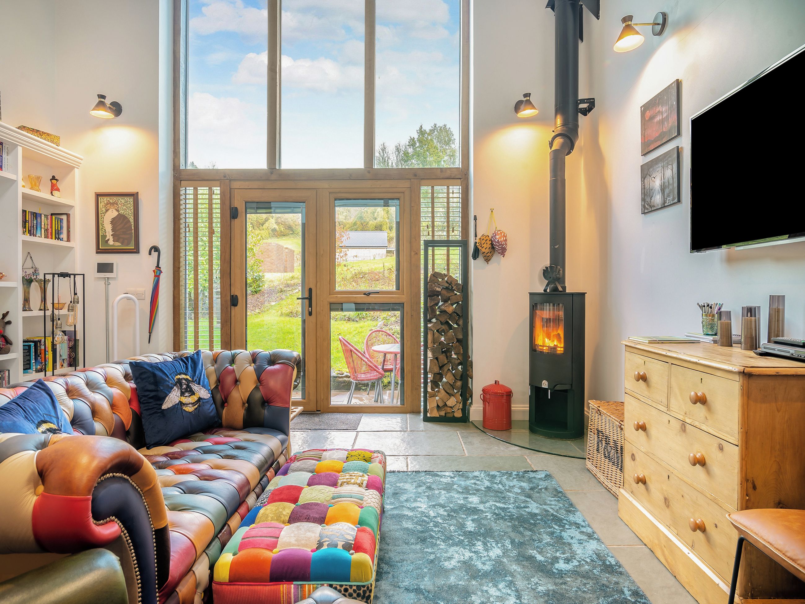 Un salon spacieux avec une grande fenêtre, une cheminée et un canapé confortable.