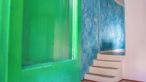 A staircase with white steps and a green door.