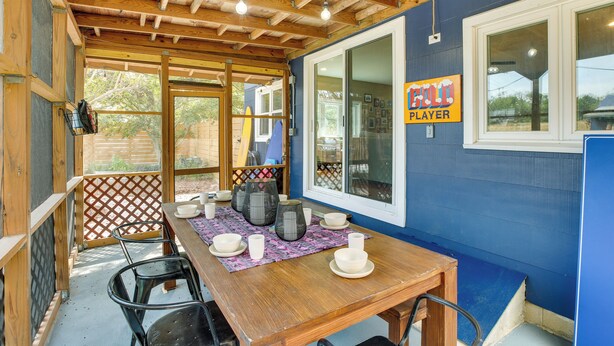 A wooden dining table with plates, bowls, and cups, a blue wall, and a window with a sign reading "ELF PLAYER". - The Blue House. 
A Family Beach House or Winter Getaway in Cape May (Cape May)
