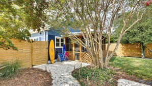 A backyard with a wooden fence, a concrete pathway, and a tree. - The Blue House. 
A Family Beach House or Winter Getaway in Cape May (Cape May)