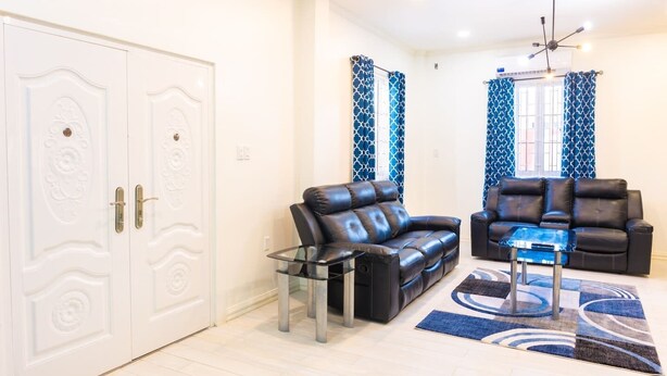 Una sala de estar con sofá, sillones, una mesa de centro y una alfombra estampada.