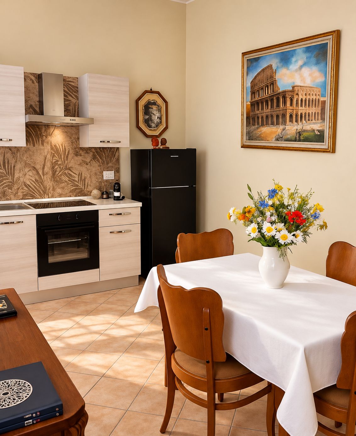 Una cocina moderna con un refrigerador negro, una estufa y un comedor con una mesa preparada para dos.