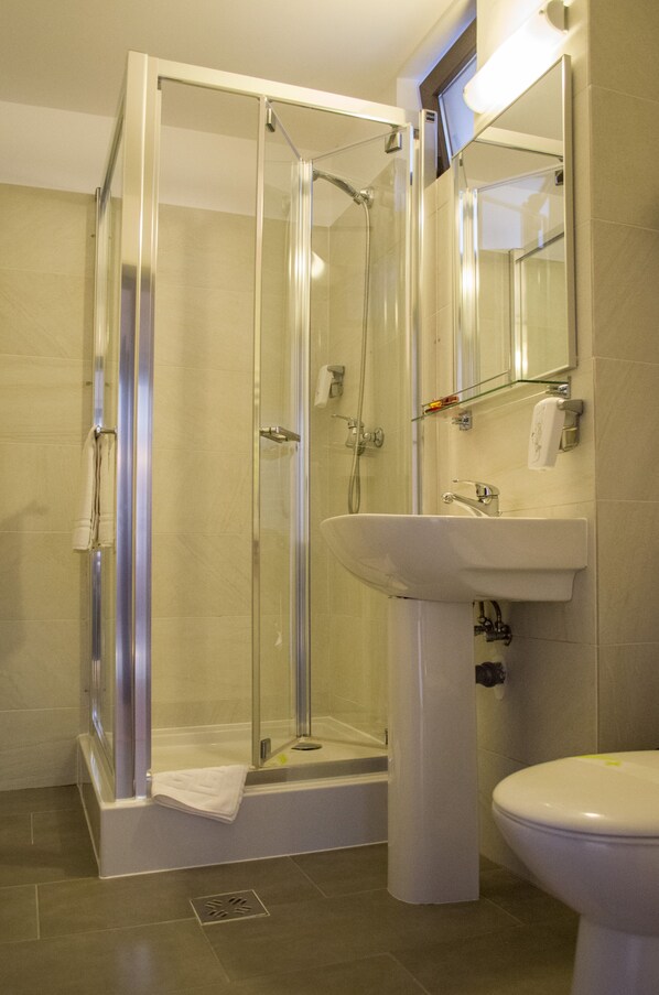 A modern bathroom with a glass-enclosed shower, a white sink, and a toilet. - Bucovina Residence & SPA (Gura Humorului)