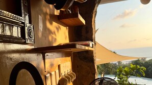 A kitchen with a sink, hanging pots, and a view of the sea. - Casa Jasmin Troncones (Troncones)