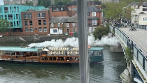 A river with a steamboat, buildings, and a bridge. - The best Windsor Castle and river Thames Panoramic views (Eton)