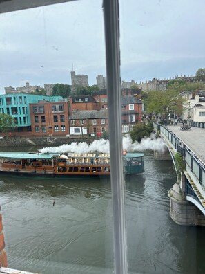 A river with a steamboat, buildings, and a bridge. - The best Windsor Castle and river Thames Panoramic views (Eton)
