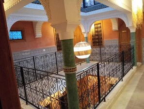 An interior corridor with ornate metal railings, a patterned floor, and a large hanging light fixture. - Charming Riad, 5 rooms (Marrakesh-Safi)