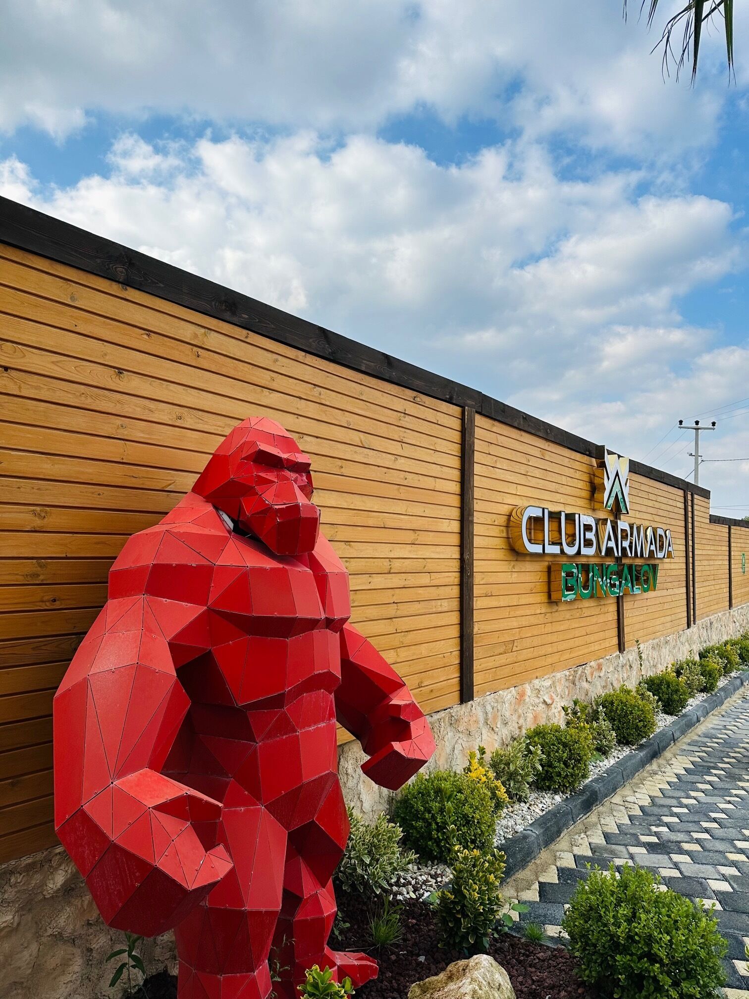 A Club Armada Bungalow with a large red geometric sculpture in front.
