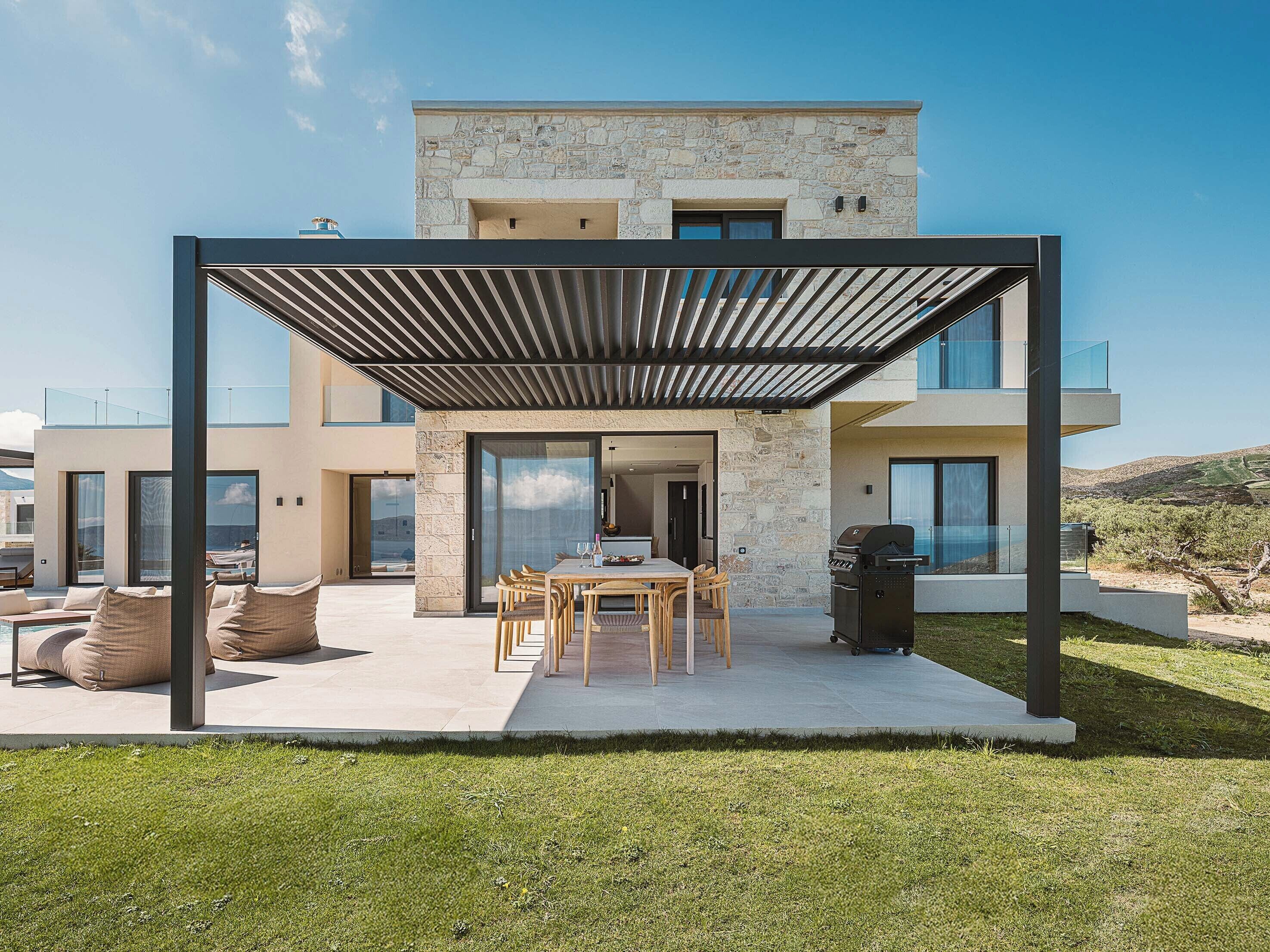 Uma casa moderna de dois andares com varanda coberta, área de jantar e churrasqueira.