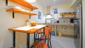 Una cocina moderna con estantes de madera, una mesa de comedor y sillas.