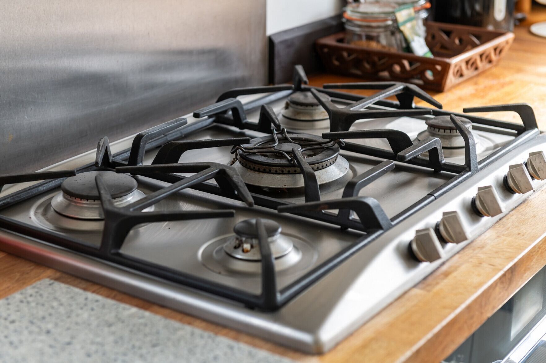 A kitchen with a stainless steel stove and a wooden countertop.