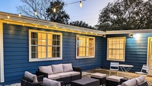 Un espace patio aménagé avec des meubles d’extérieur et des guirlandes lumineuses.