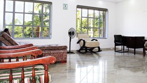 A spacious room with large windows, a fan, and a desk. - Finca Hotel Villa Gladys (El Colegio)