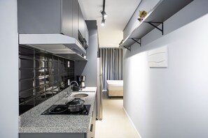 Cozinha moderna com fogão embutido, eletrodomésticos de aço inoxidável e design minimalista.