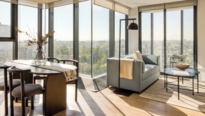 Een moderne woonkamer met een groot raam, een bank, een eettafel en een salontafel.
