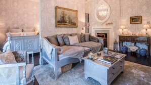 Une chambre classique avec un lit, une commode, un miroir et une cheminée.