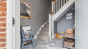 A staircase with a grey wall, a blue chair, and patterned floor tiles. - No. 4 - Oak Tree Cottage - Pass the Keys (Middlethorpe)