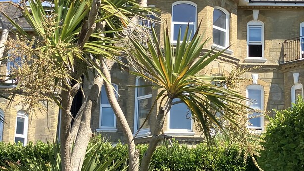A stone building with multiple windows and a sloped roof. - Bermuda House with parking, good sea view and minutes from beach and shops (Ventnor)